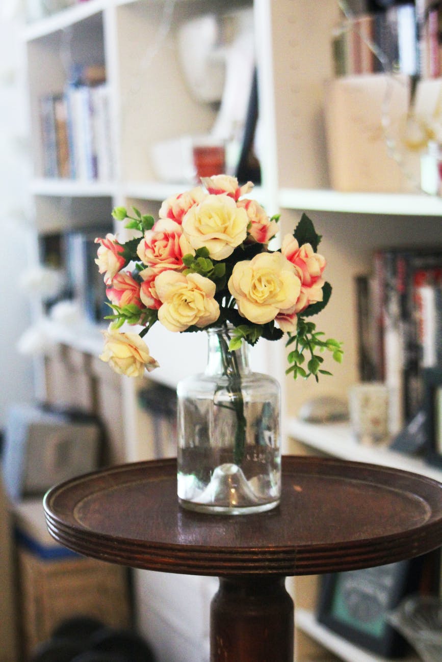 arrange of petal flower in clear glass vase at table